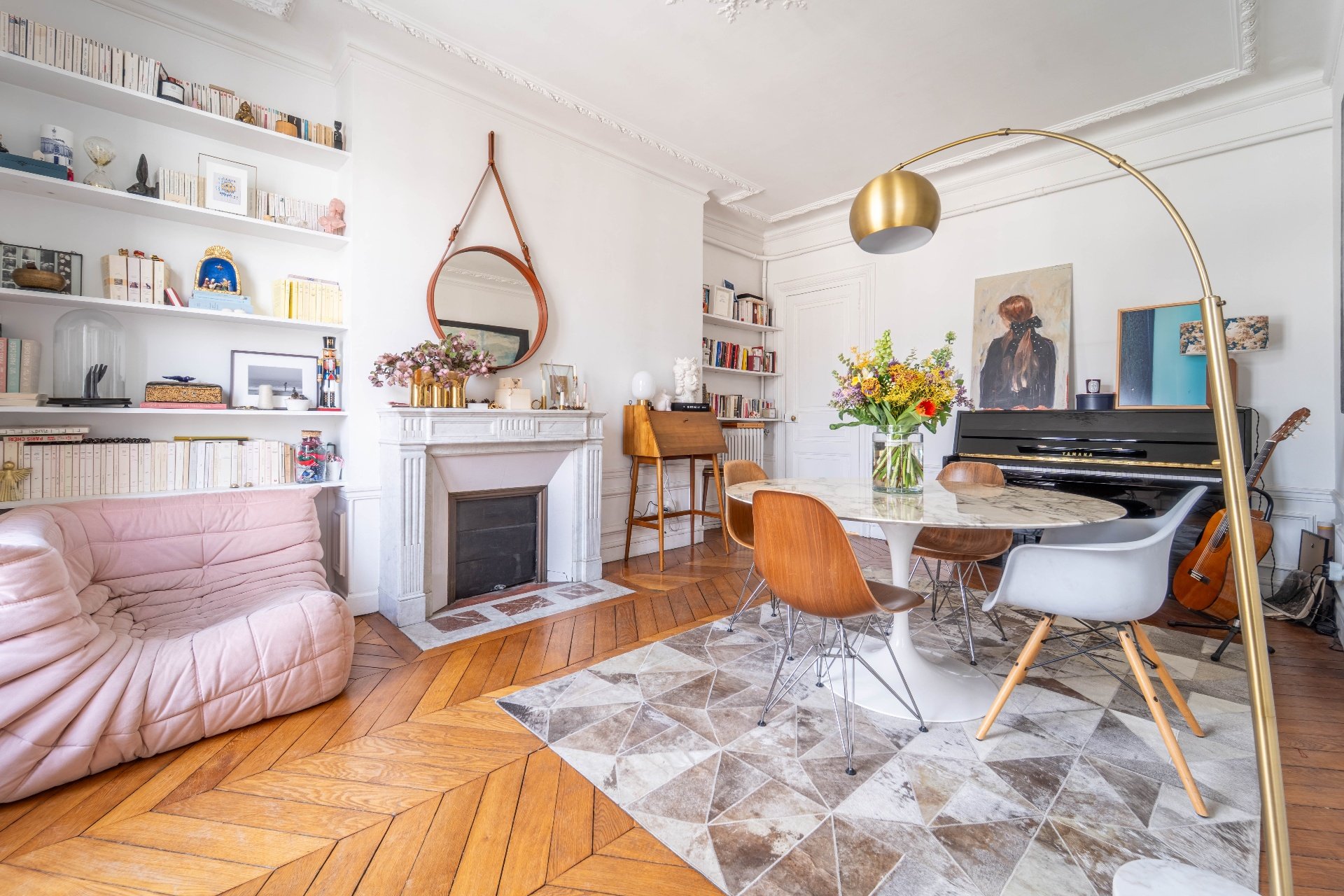 Salon parisien avec cheminée en marbre, canapé Togo rose et piano