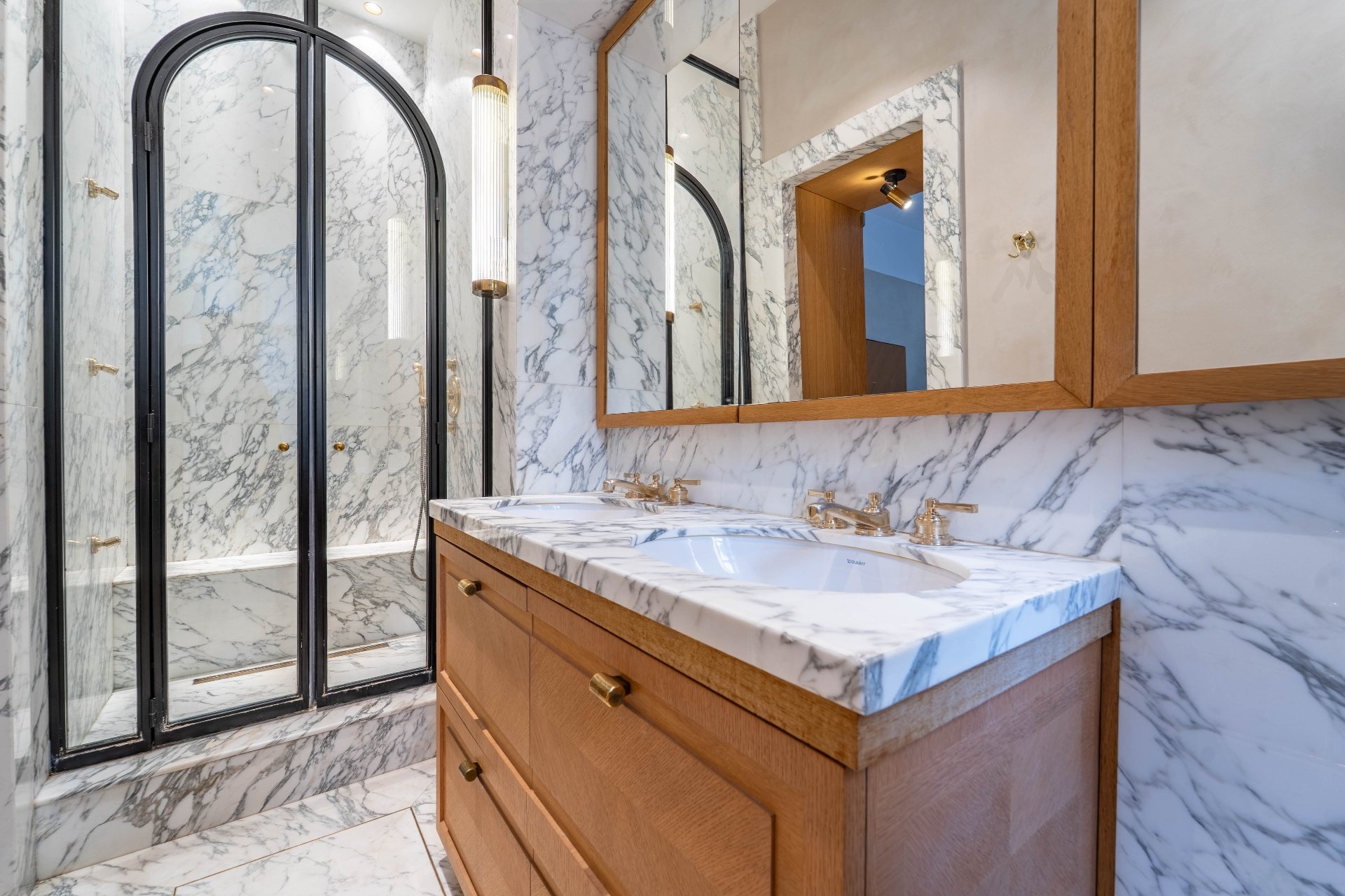 Salle de bain luxueuse en marbre avec double vasque et miroir